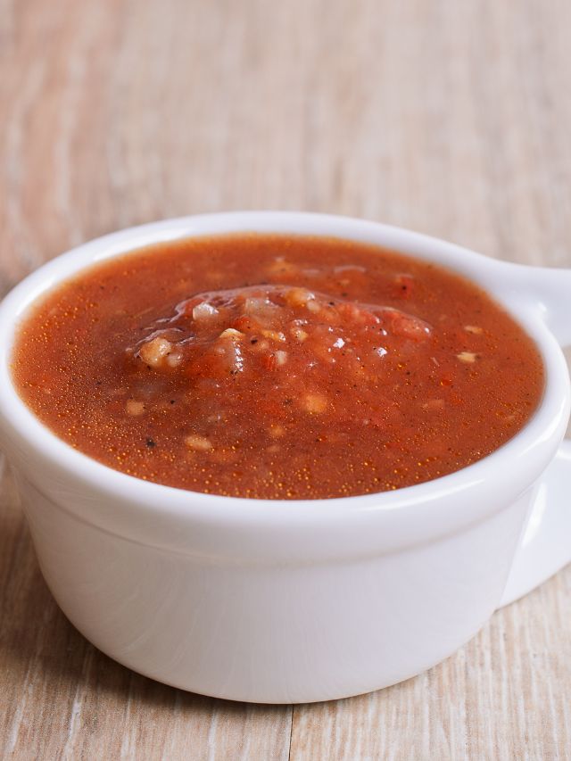 red sauce in a white ceramic bowl on a wooden surface