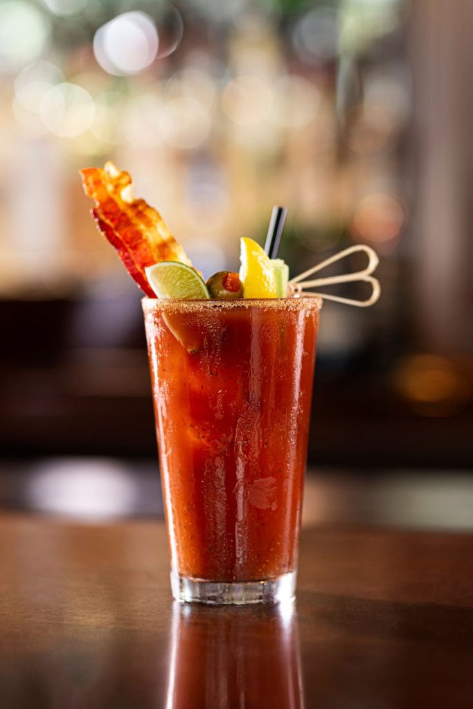 A bar serving bloody marys topped with bacon.