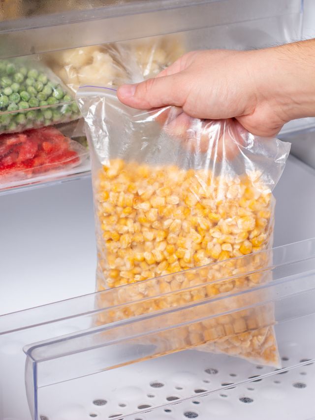 freezer bag of corn being put into a fridge