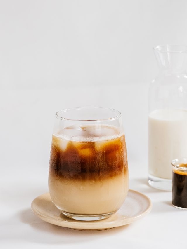 a glass of iced coffee sitting on a coaster