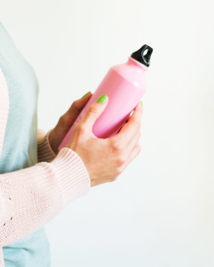 woman holding a pink water bottle