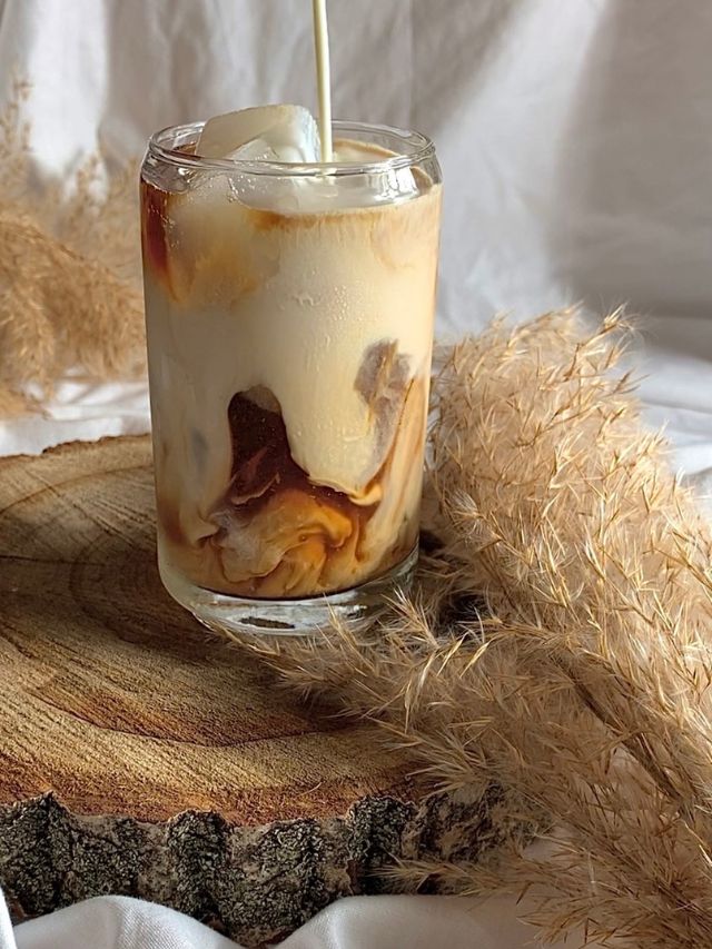 iced coffee in a clear glass on wooden block