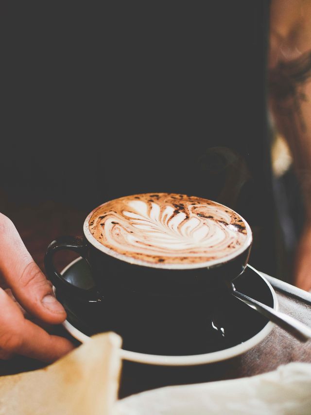 black coffee mug with cappuccino in it