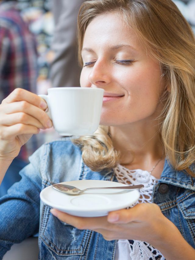 a girl smelling her coffee