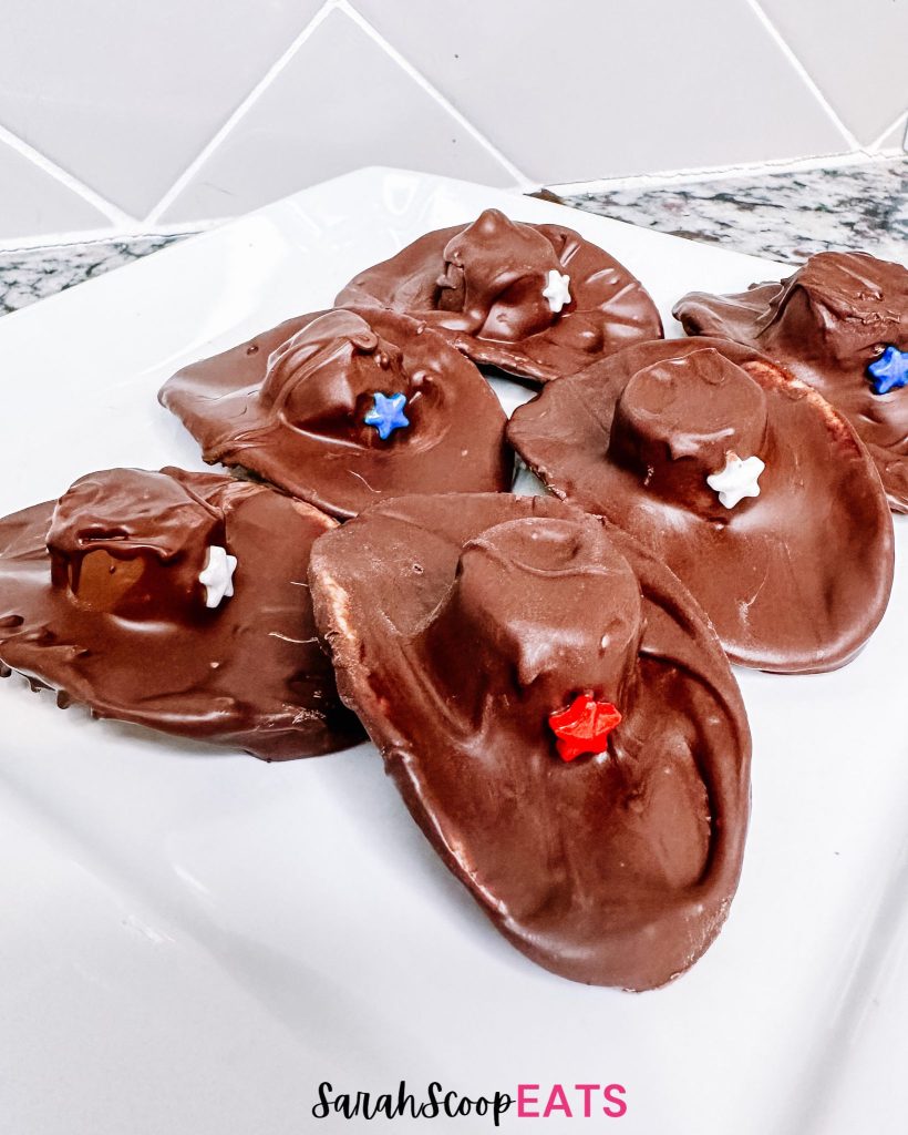 6 4th of july chocolate cowboy hats with red white and blue stars on a white plate
