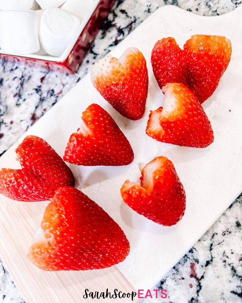 strawberries cut in heart shapes on a white platter