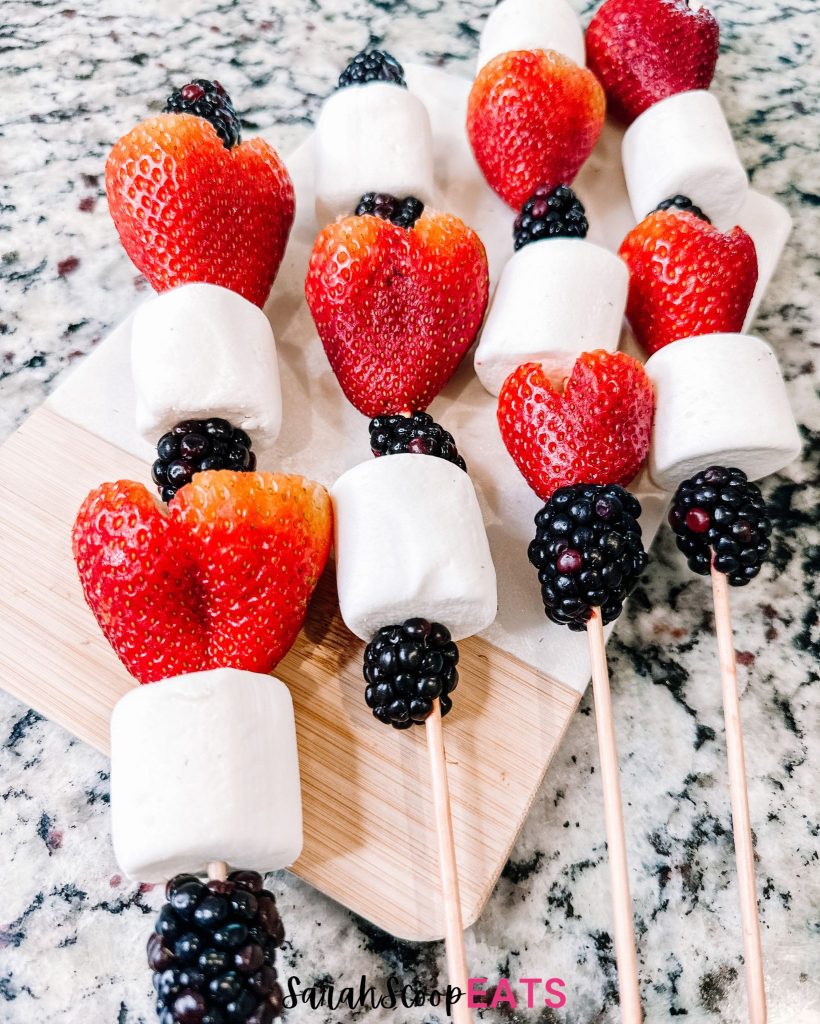 4 completed 4th of july fruit skewers on a wooden board ready to serve