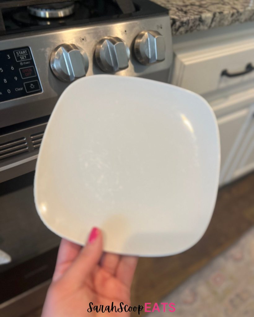 holding plate in kitchen in front of oven
