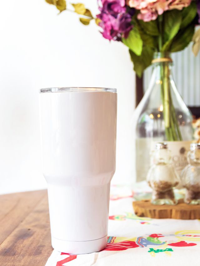 white tumbler on table with flowers