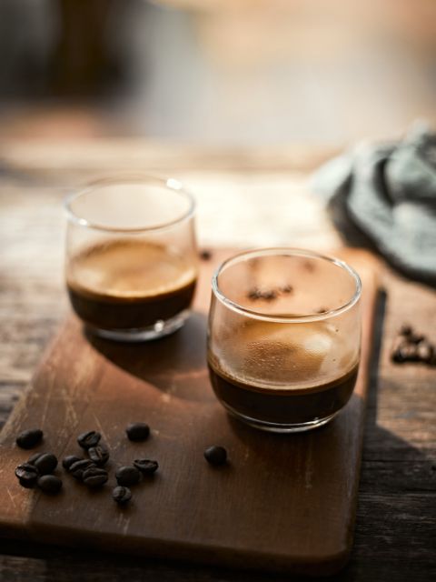 shots of espresso on wooden board and beans