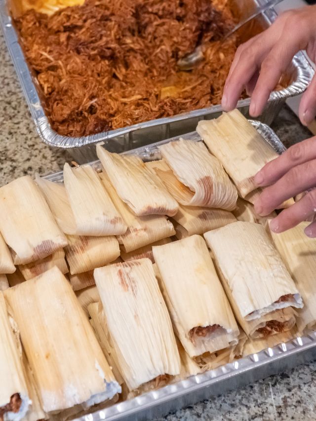 person laying out tamales to make them