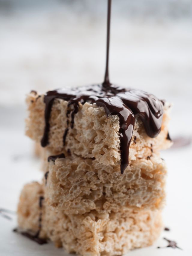 pouring chocolate on top of rice krispie treats