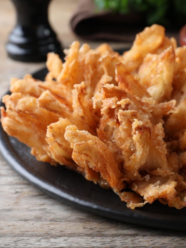blooming onion on a black plate