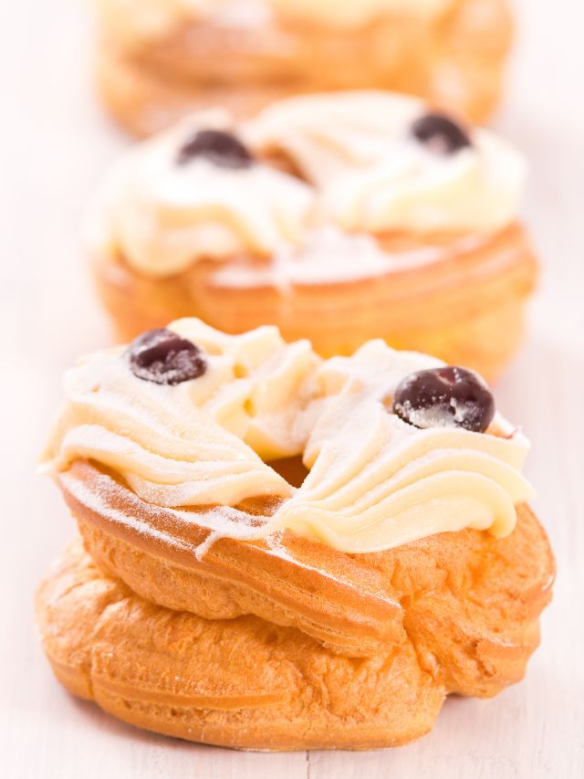 zeppoles in a line with frosting and topping
