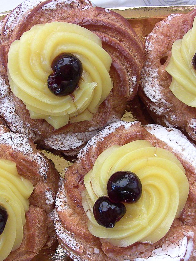 a couple of zeppoles with frosting and topping