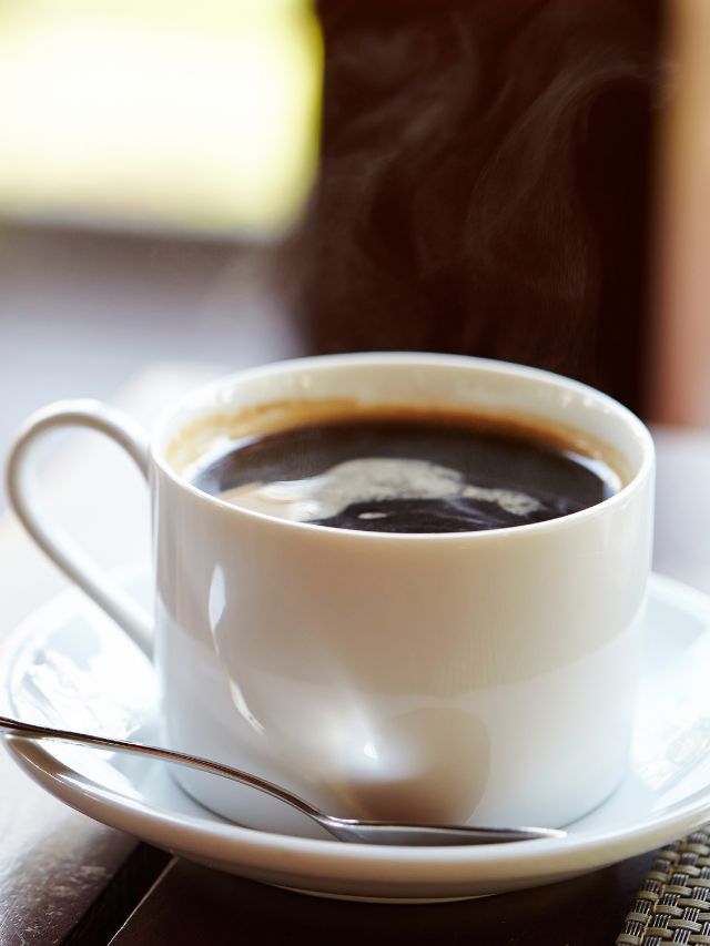 hot black coffee in coffee mug and spoon