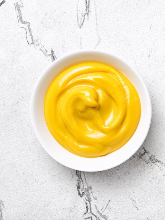 yellow sauce in a white dish on a marble background