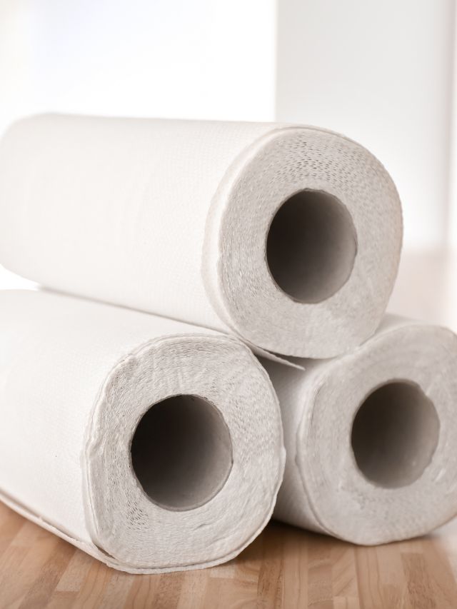 rolls of paper towels stacked on wooden table