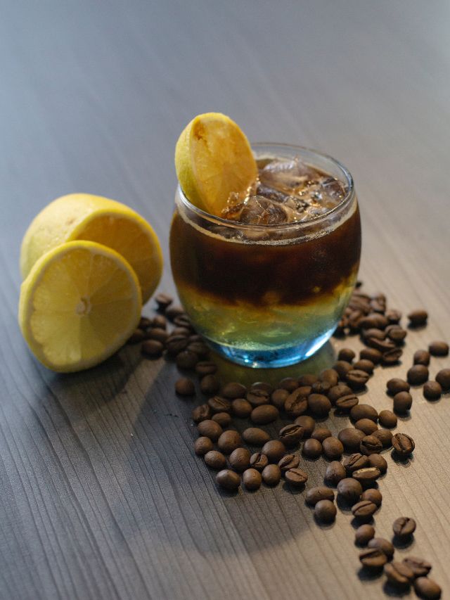 small glass of coffee with lemons and coffee beans