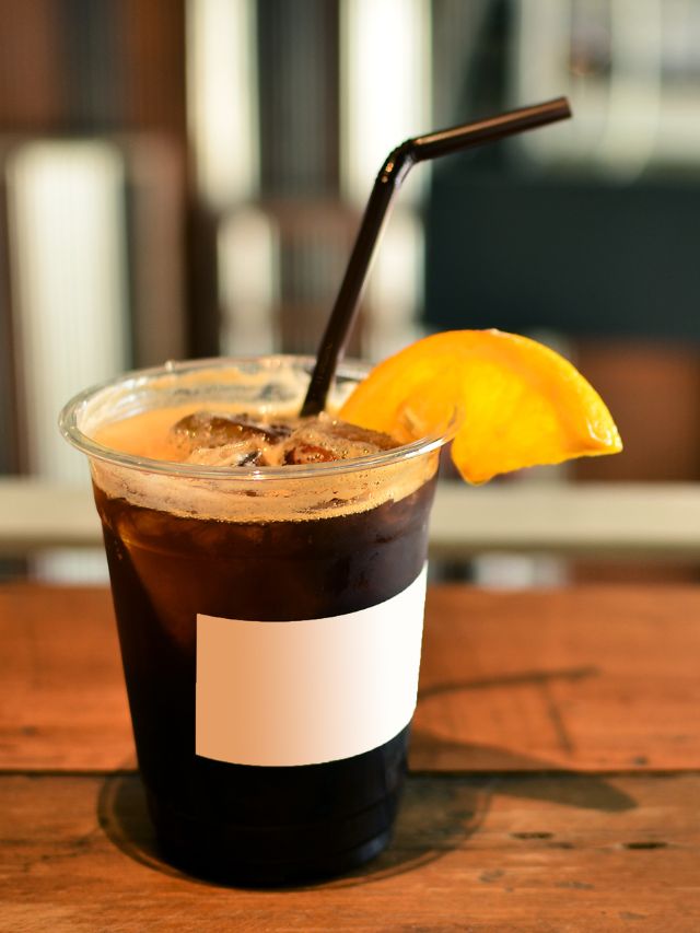 iced coffee in glass with straw and lemon
