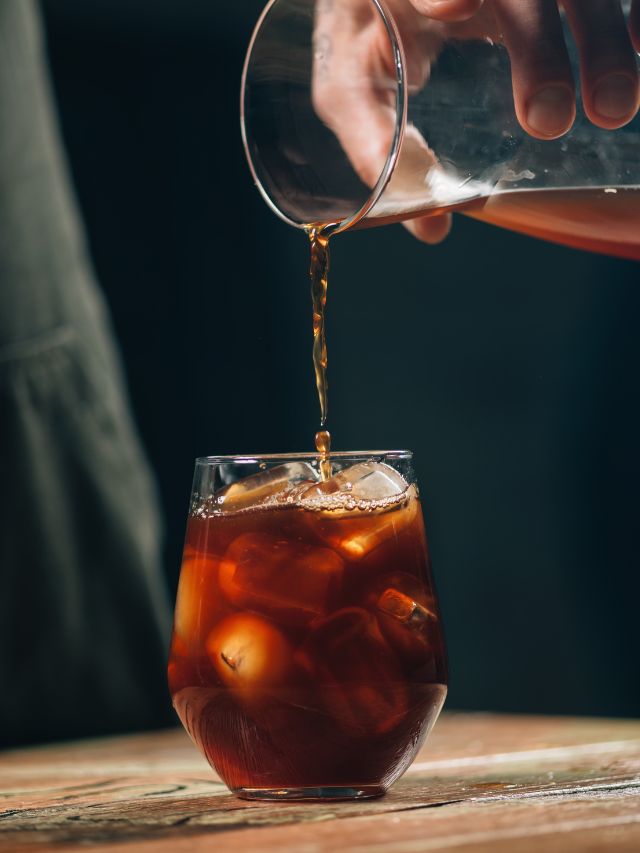 pouring cold brew into a cup