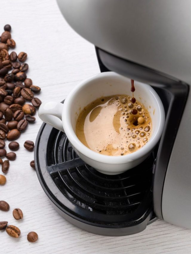 A coffee machine with coffee beans and a cup of coffee.
