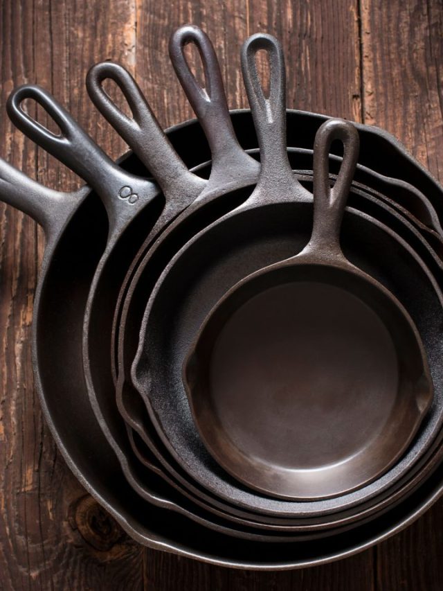 Five cast iron skillets stacked on top of each other.