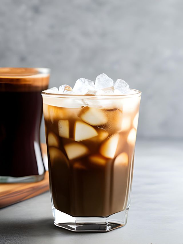 Two glasses of iced coffee on a wooden table.