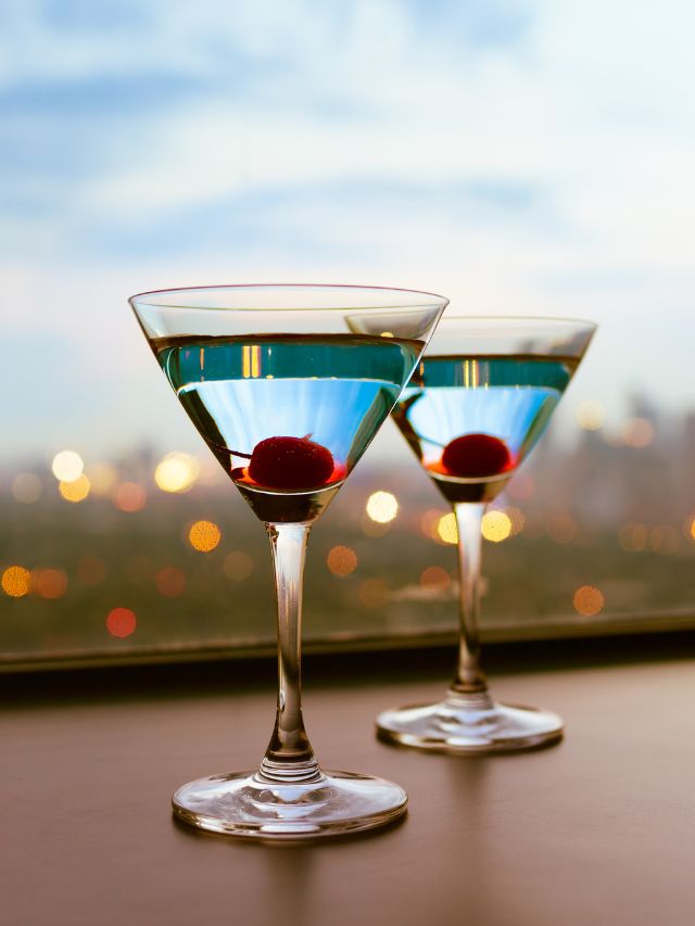 two martini glass filled with empress and cherries in each