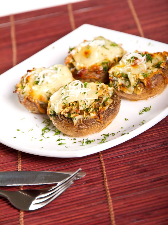 plate of stuffed mushrooms with fork and knife