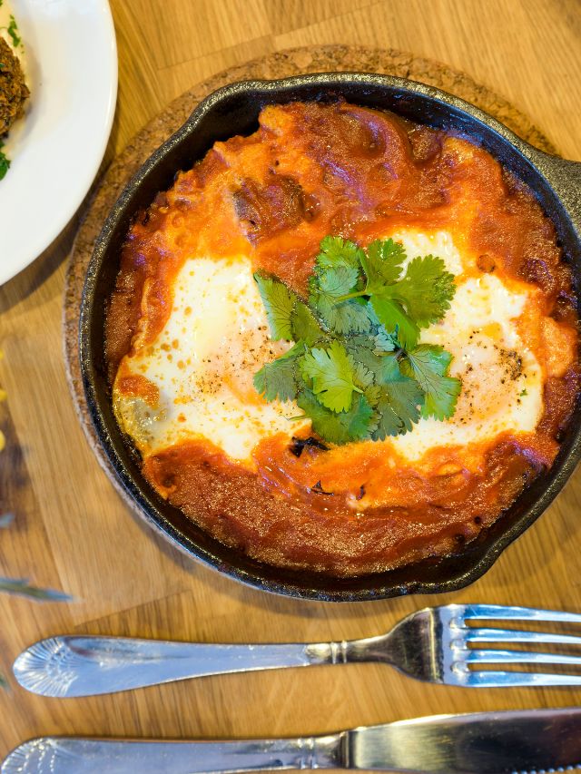 skillet with shakshuka and fork and knife