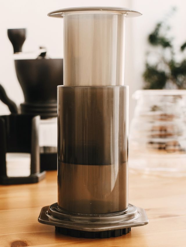 A coffee maker sitting on a wooden table.