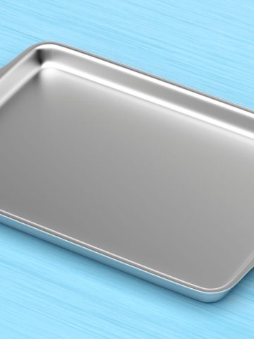 A metal baking tray on a blue background.