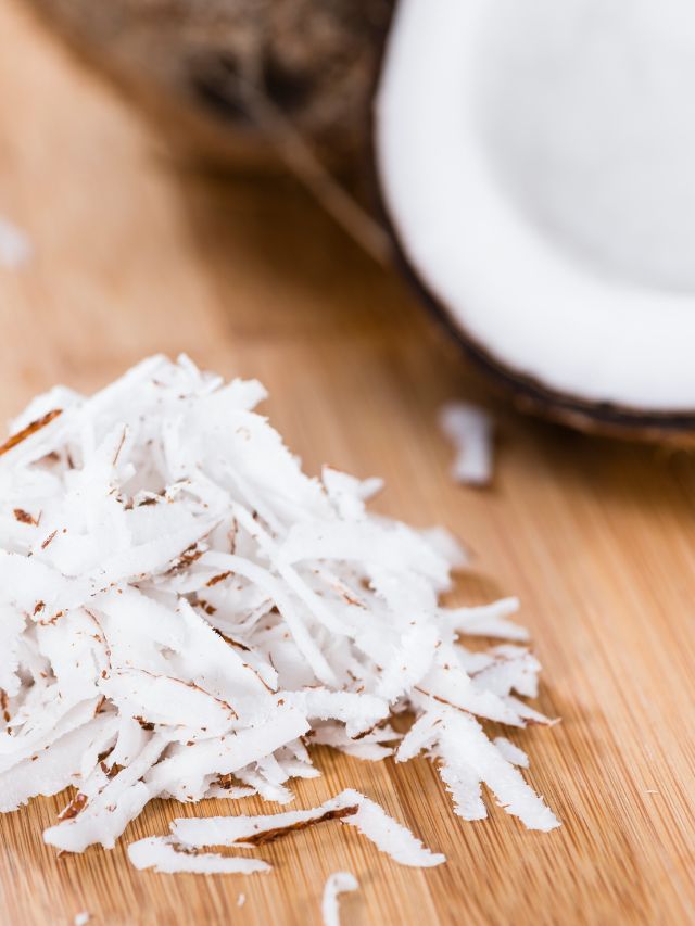Coconut flakes on a wooden table, substituting for coconut milk.