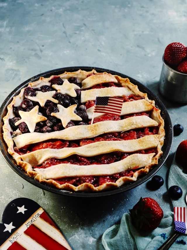 An american flag pie with strawberries and blueberries.