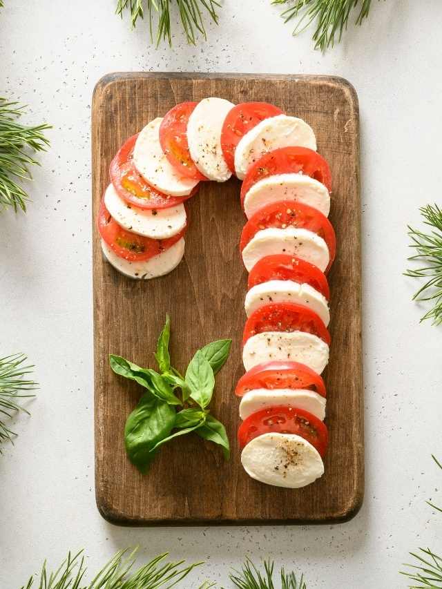 A cutting board with tomatoes, mozzarella and basil.