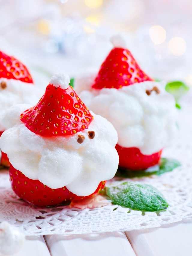 Three santa claus shaped strawberries on a lace doily.