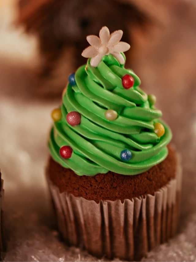 Two cupcakes decorated with a christmas tree.