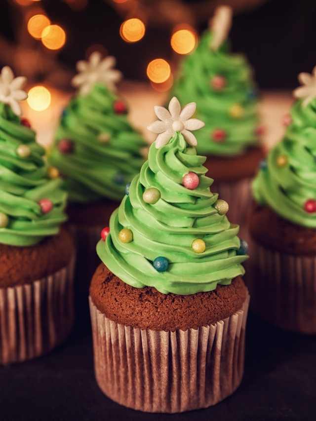 A group of cupcakes decorated with christmas trees.