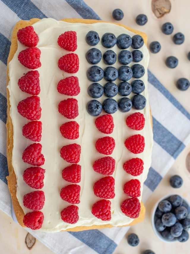 An American flag cake adorned with raspberries and blueberries, perfect for celebrating the 4th of July.