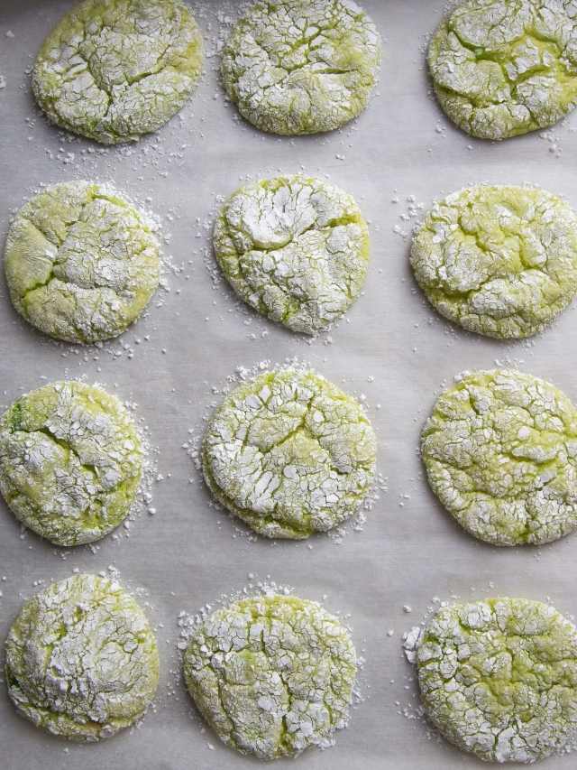 Lime sugar cookies on a baking sheet with powdered sugar.