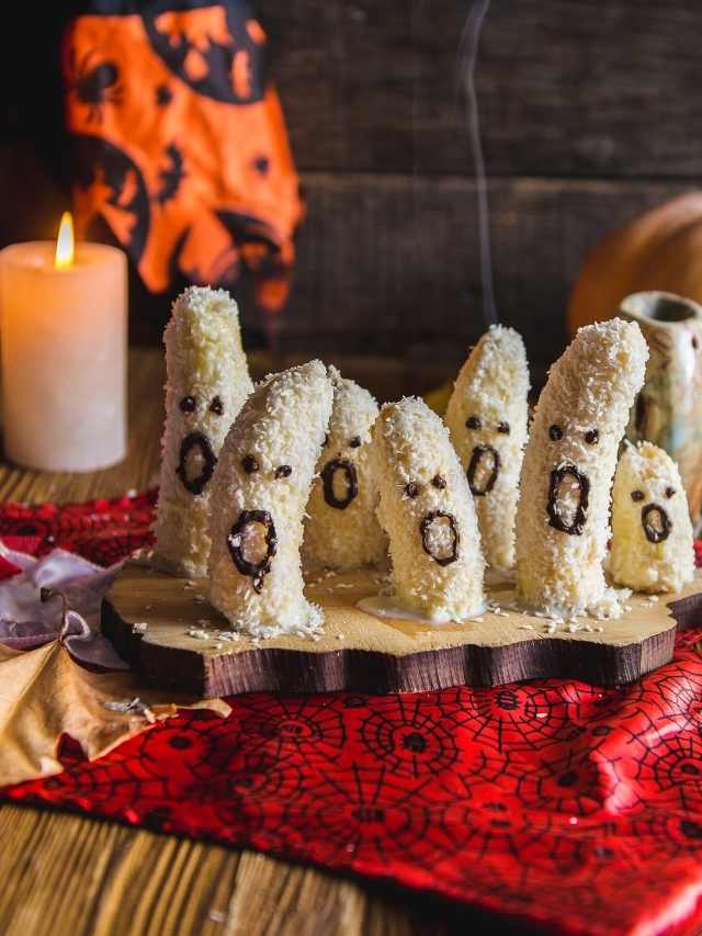 Coconut ghosts on a wooden board with candles.