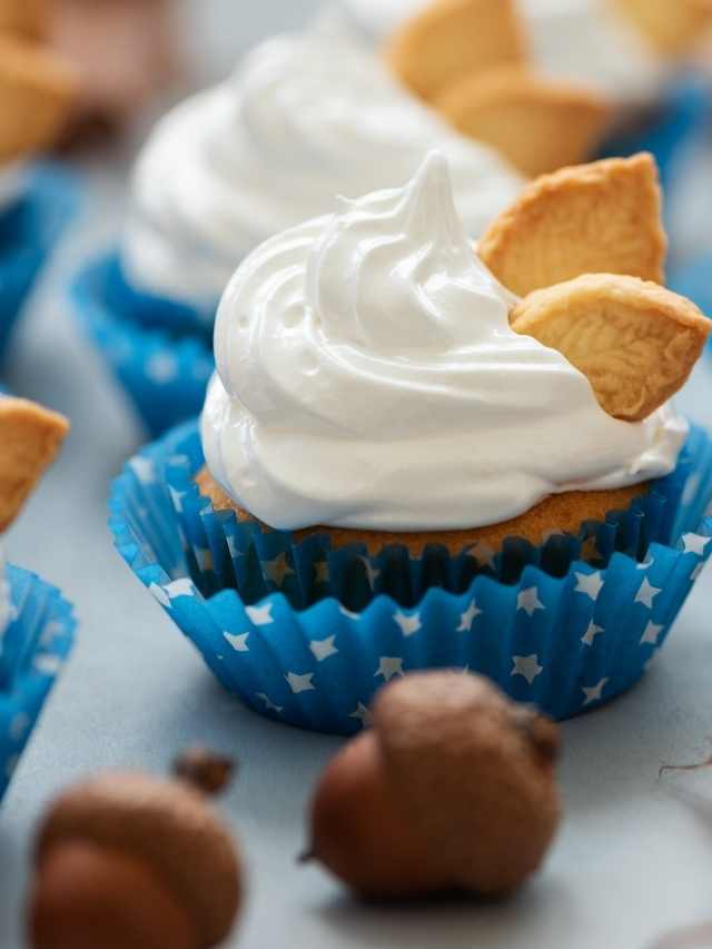 Cupcakes topped with whipped cream and nuts.