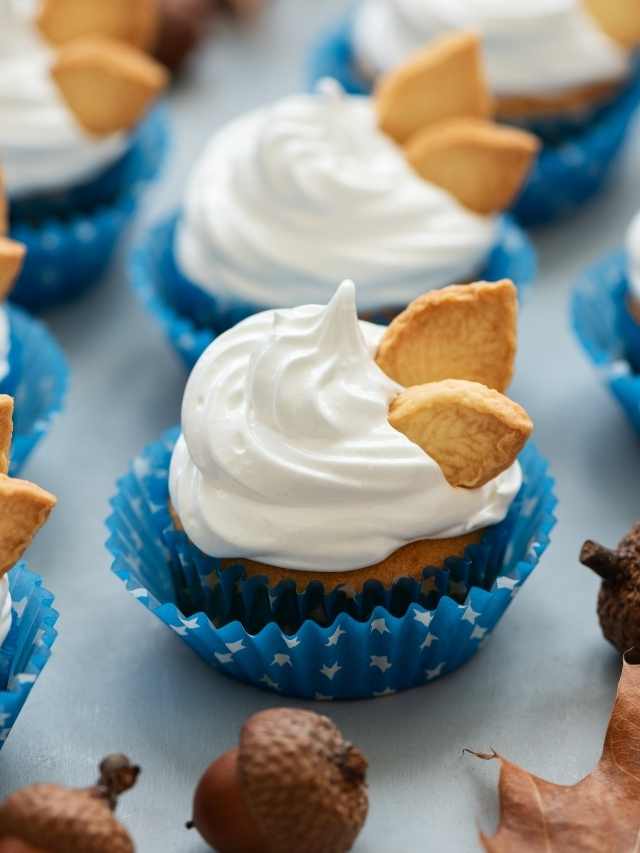 Cupcakes topped with whipped cream and acorns.
