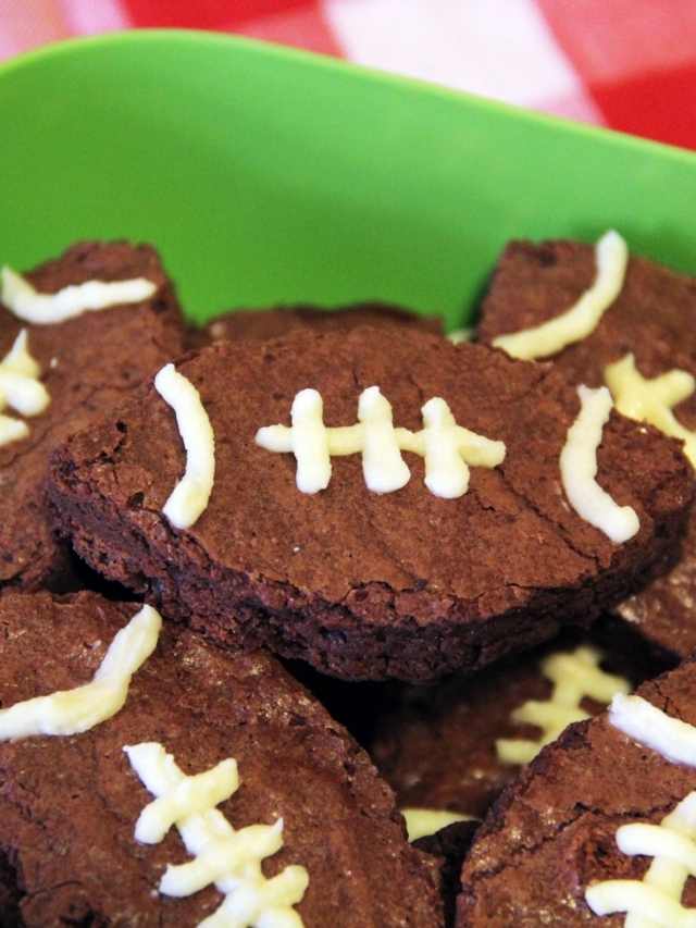 Football cookies in a green bowl.