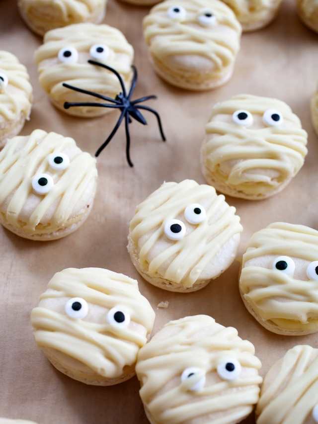 Mummy macarons with eyes and spiders on top.