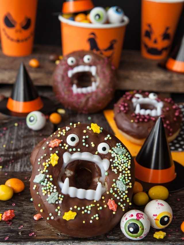 Halloween donuts and candy on a wooden table.