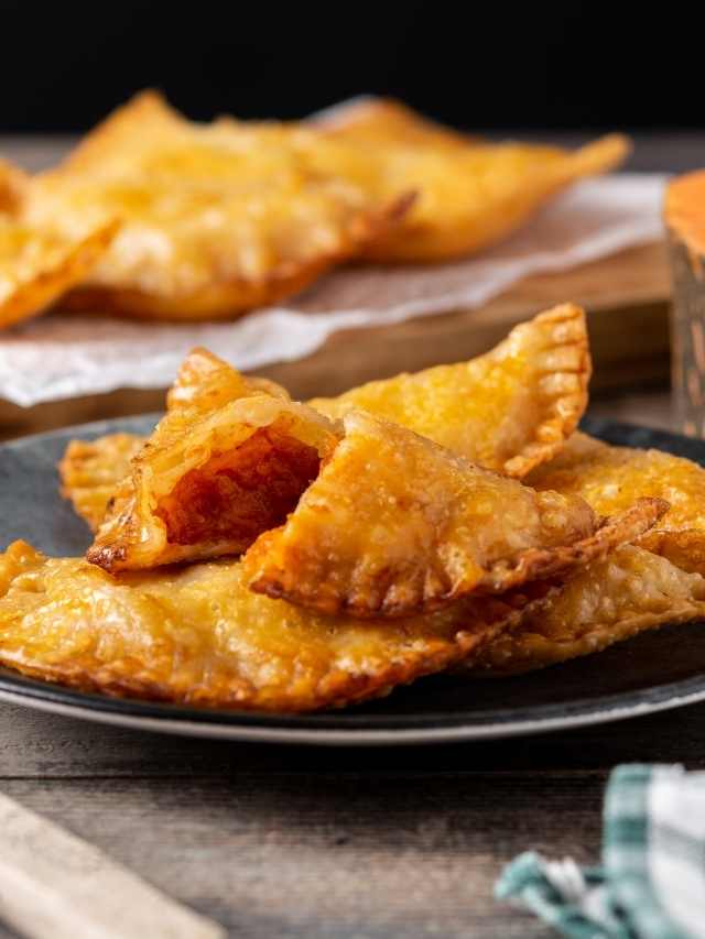 A plate of fried empanadas on a wooden table.
