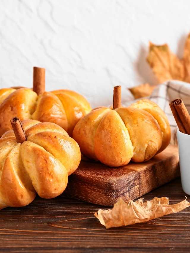 Pumpkin bread on a wooden table with cinnamon sticks.