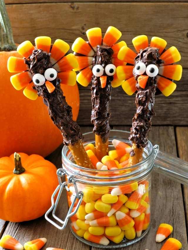 Three turkey pretzel sticks with candy corn in a jar.